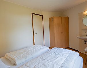 Ruime slaapkamer in Bungalow Uterste Coogh 98, De Dennen, Texel met extra voorzieningen en veel opbergruimte.