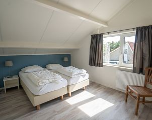 Lichte bovenverdieping slaapkamer in Vakantiehuis 't Hoogelandt 136, Texel, met uitzicht op tuin.