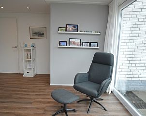 Stijlvolle leeshoek in Vakantiehuis de Parel 168, De Dennen, Texel, met uitzicht op de natuurlijke omgeving van de Waddeneilanden.