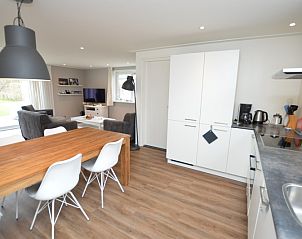 Eetruimte in Vakantiehuis de Parel 168, De Dennen, Texel, met ruime tafel en moderne keukenfaciliteiten.