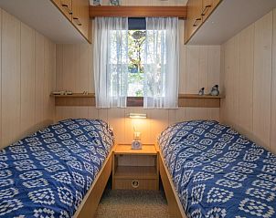 Cozy bedroom with two beds in Vakantiepark de Bremakker Weideveld 61, Texel, vacation home in De Dennen.