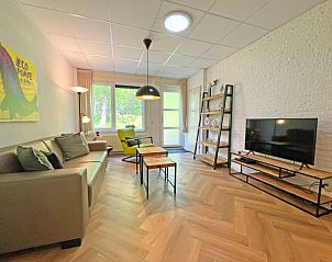 Gerumiges Wohnzimmer des Appartements Bos en Duin 05, De Dennen, Texel mit einem Flachbildfernseher.