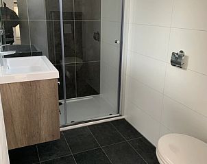 Moderne badkamer in Chalet 1140 van Vakantiepark De Bremakker, gelegen in De Dennen, Texel, met stijlvolle douche en wastafel.