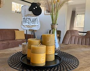 Gezellige woonkamer van Vakantiepark De Bremakker - Chalet 1140 in De Dennen, Texel, met sfeervolle kaarsen en decoraties.