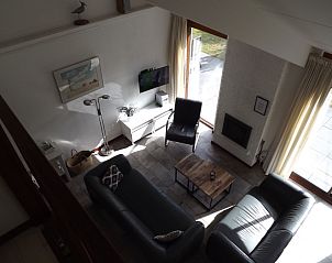 Gezellige woonkamer in Vakantiehuis Gortersmient 326, De Dennen, Texel met comfortabele zitplaatsen en open haard.