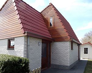 Buitenkant van Vakantiehuis Gortersmient 326 in De Dennen, Texel, met charmante architectuur en rode dakpannen.