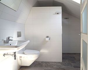Moderne badkamer in Vakantiehuis Gortersmient 326, De Dennen, Texel, met strakke witte tegels en douche.
