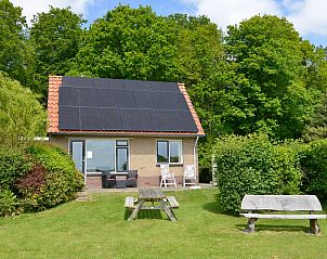 't Wambas vakantiehuis in De Dennen, Texel met zonnige tuin en zitplek, omgeven door groene natuur.