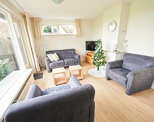 Gezellige woonkamer van 't Wambas vakantiehuis in De Dennen, Texel met comfortabele banken en uitzicht op de tuin.