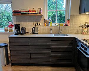 Keuken met uitzicht op de tuin in Bungalowpark Gortersmient - Blommenzee, De Dennen, Texel. Praktisch en stijlvol.