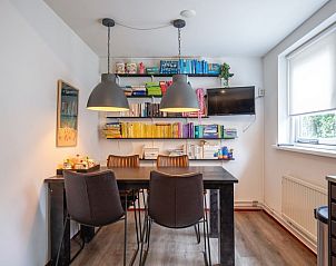 Sfeervolle eetkamer met boekenplanken in Bungalowpark Gortersmient - Blommenzee, De Dennen, Texel.