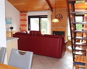 Knusse woonkamer met grote ramen in Vakantiehuis Gortersmient 300, De Dennen, Texel. Geniet van het uitzicht en de natuur op de Waddeneilanden.