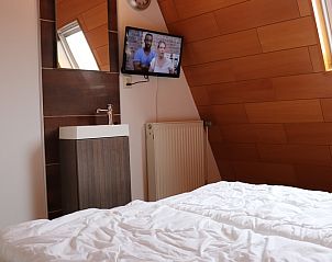 Sfeervolle slaapkamer met televisie in Vakantiehuis Gortersmient 300, De Dennen, Texel. Vakantiewoning voor een ontspannen verblijf.