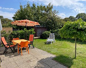 Gerumiger Garten des Bungalowparks Uterste Coogh - Bungalow 84, De Dennen, Texel, mit Sitzgelegenheiten und grner Natur.