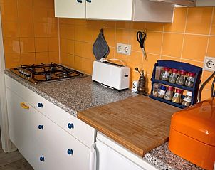 Moderne Kche im Bungalowpark Uterste Coogh - Bungalow 84, De Dennen, Texel, ausgestattet mit bunten Fliesen und Gerten.