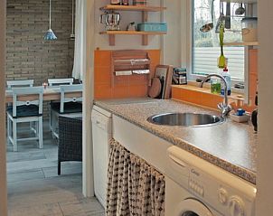 Funktionelle Kche mit Waschmaschine im Bungalowpark Uterste Coogh - Bungalow 84, De Dennen, Texel, mit Blick auf den Essbereich.