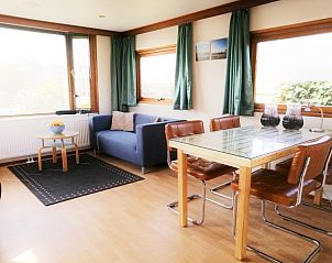 Gezellige binnenruimte bij Vakantiepark De Koorn-aar - Chalet 102 type C, De Dennen, Texel met zithoek en eetgedeelte.