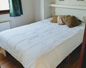 Comfortabele slaapkamer in Vakantiepark De Koorn-aar - Chalet 102 type C, De Dennen, Texel met knusse sfeer en opbergruimte.