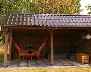 Overdekt terras met hangmat in Vakantiepark De Koorn-aar - Chalet 102 type C, De Dennen, Texel voor ontspanning in de buitenlucht.