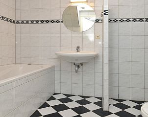 Luxe badkamer met bad en wastafel in vakantiehuis Turel, De Dennen, Texel.