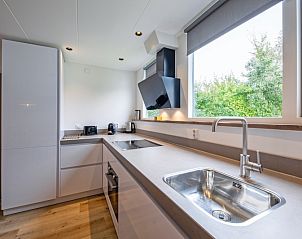 Moderne Kche im Ferienhaus de Parel 166, Texel. Vollstndig ausgestattet mit Blick auf die grne Umgebung von De Dennen.