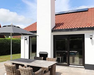 Buitenruimte met parasol bij Vakantiehuis Gortersmient 302, De Dennen, Texel.