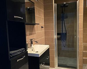 Badkamer in Helianthus vakantiehuis De Dennen Texel met ruime douche en moderne wastafel.