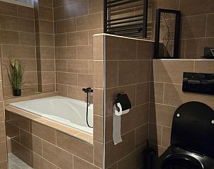 Luxe badkamer in Helianthus vakantiehuis De Dennen Texel met ligbad en modern toilet.