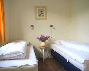 Comfortabele slaapkamer in Duinpieper vakantiehuis, De Dennen, Texel met twee bedden.