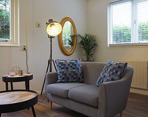 Gezellige zithoek in Duinpieper vakantiehuis, De Dennen, Texel met comfortabele bank.