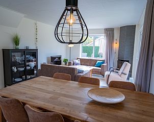 Stijlvolle eetkamer in Vakantiehuis 't Hoogelandt 134, De Dennen, Texel met houten tafel en moderne verlichting.