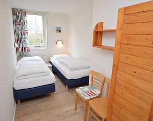 Sfeervolle slaapkamer in Bungalow Verste Coogh 140, De Dennen, Texel met comfortabele bedden.