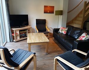 Gemtliches Wohnzimmer in Bollenveld - de Iris, Ferienhaus De Dennen, Texel mit bequemer Sitzecke und Fernseher.