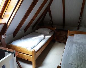 Mansardenzimmer mit Holzbalken und Betten in Bollenveld - das Iris-Ferienhaus, De Dennen, Texel.