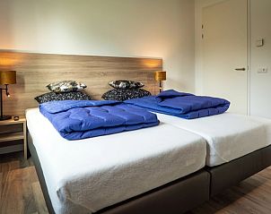 Komfortables Schlafzimmer im Ferienpark De Koorn-aar Villa, Texel mit Doppelbett.