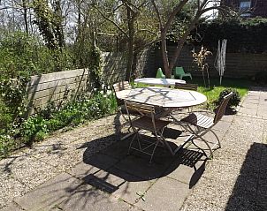Genieen Sie den sonnigen Garten des Ferienhauses Gortersmient 254 in De Dennen, Texel, mit einer schnen Terrasse inmitten der Natur.