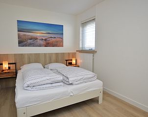 Slaapkamer in Bungalowpark 't Luwe Land - Bungalow 13c, De Dennen, Texel, met tweepersoonsbed en sfeervolle verlichting.