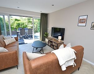 Gerumiges Wohnzimmer des Bungalows 't Hoogelandt 58, Texel, mit Zugang zur sonnigen Terrasse.