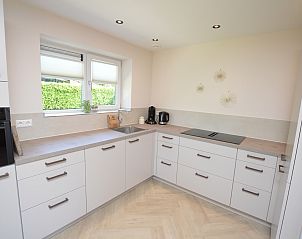 Moderne Kche im Bungalow 't Hoogelandt 58, Texel, mit schlichter Verarbeitung und viel Stauraum.