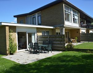 Vakantiehuis Iris in De Dennen, Texel met zonnig terras en groene tuin voor ontspanning.