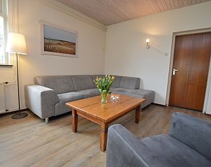 Moderne zithoek in vakantiehuis Iris, Texel, ideaal voor ontspanning na een dag op de Waddeneilanden.