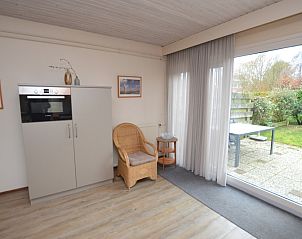 Zitgedeelte met toegang tot het terras in vakantiehuis Iris, Texel, ideaal voor binnen-buiten leven.