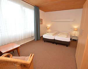 Slaapkamer in vakantiehuis Iris, Texel met comfortabele bedden en rustgevende sfeer.