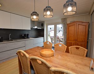 Esszimmer und Kche im Ferienhaus de Parel 206 in De Dennen, Texel mit Esstisch aus Holz.