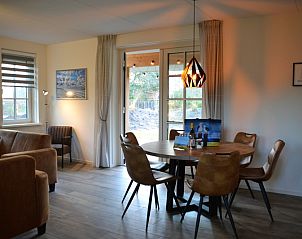 Ruime woonkamer met toegang tot veranda in Golden Raand, Texel.