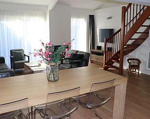 Stijlvolle eetkamer in Vakantiehuis Gortersmient 232, Texel, met houten tafel en glazen stoelen.