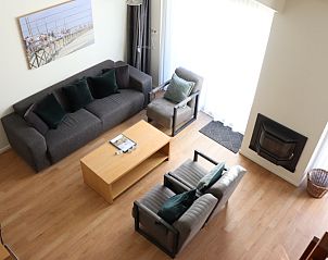 Lichte woonkamer van Vakantiehuis Gortersmient 232, De Dennen, Texel met zithoek en schilderij aan de muur.