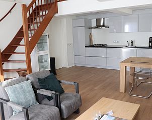 Gezellige woonruimte in Vakantiehuis Gortersmient 232, Texel met open keuken en comfortabele zitplaatsen.