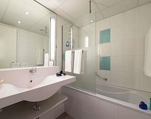Moderne badkamer met bad en douche in Novotel Maastricht appartement.