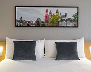 Sfeervolle slaapkamer met kunstwerk in Novotel Maastricht accommodatie.